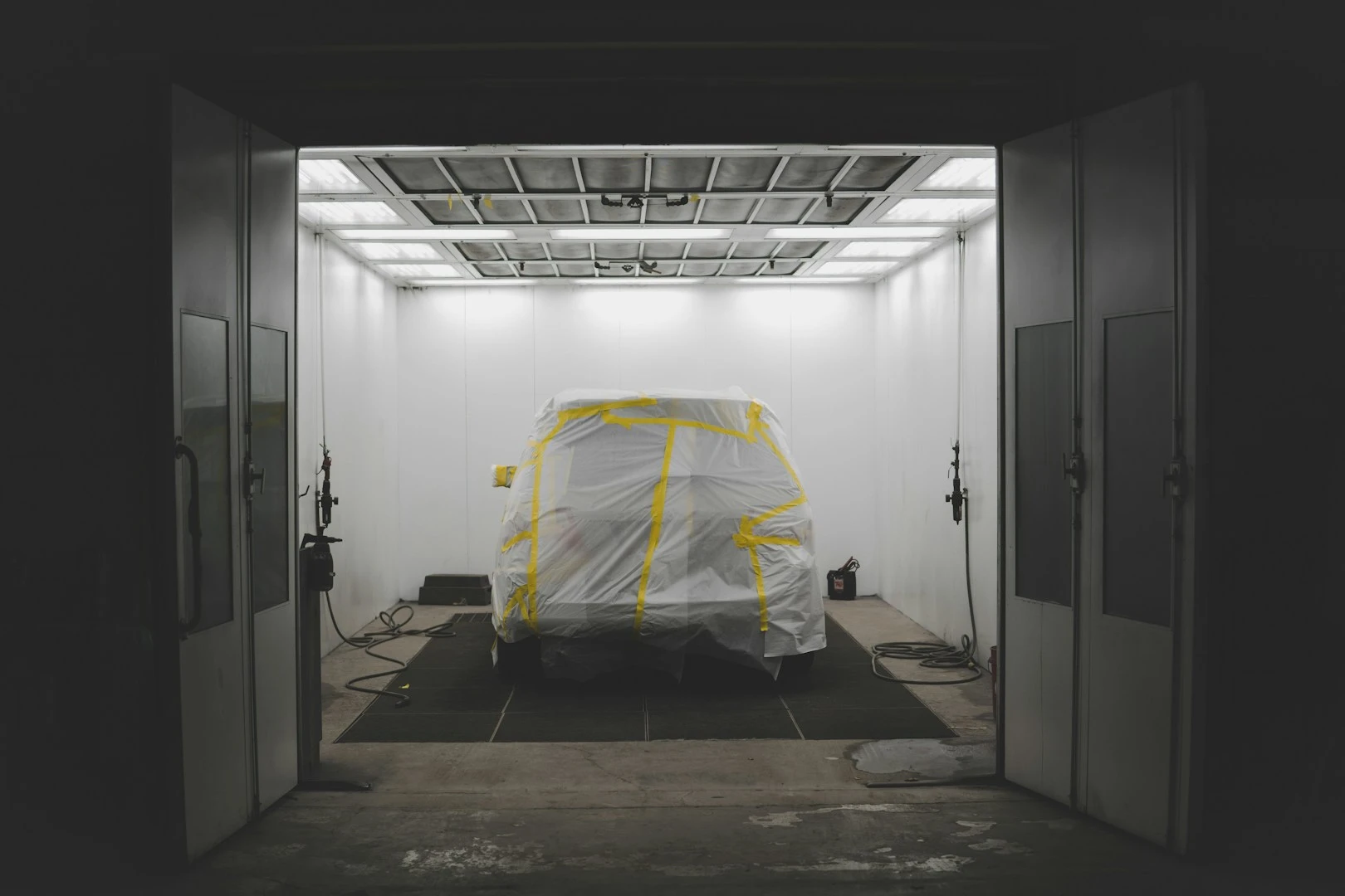 A vehicle prepared inside an illuminated refinishing bay