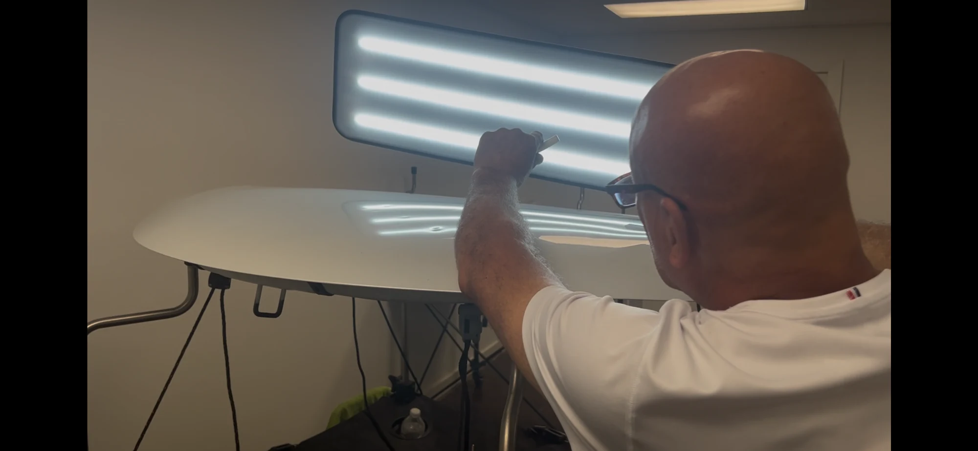 DriveUp technician performing paintless dent repair on a white vehicle